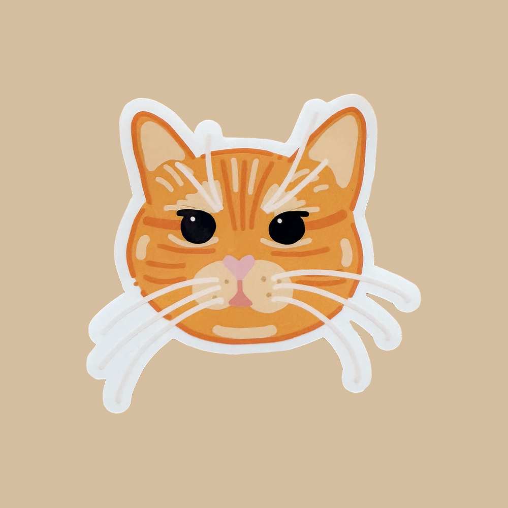 Cartoon orange cat face sticker on a beige background. 